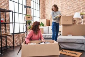 A mother helps her daughter to move her belongings into a new flat